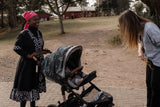 Black and gray patterned stroller with a canopy featuring rainbow arcs