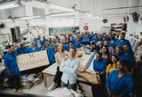 Blue work uniforms worn by a group of people in a workshop setting.