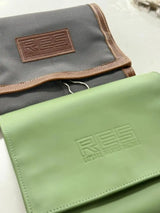 Gray and green res branded travel toiletry bags with brown leather accents.