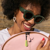 Pink leather backpack with a neon yellow zipper pull and black zippers