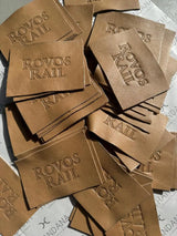 Tan leather patches with ’rovos rail’ embossed in a classic serif font.